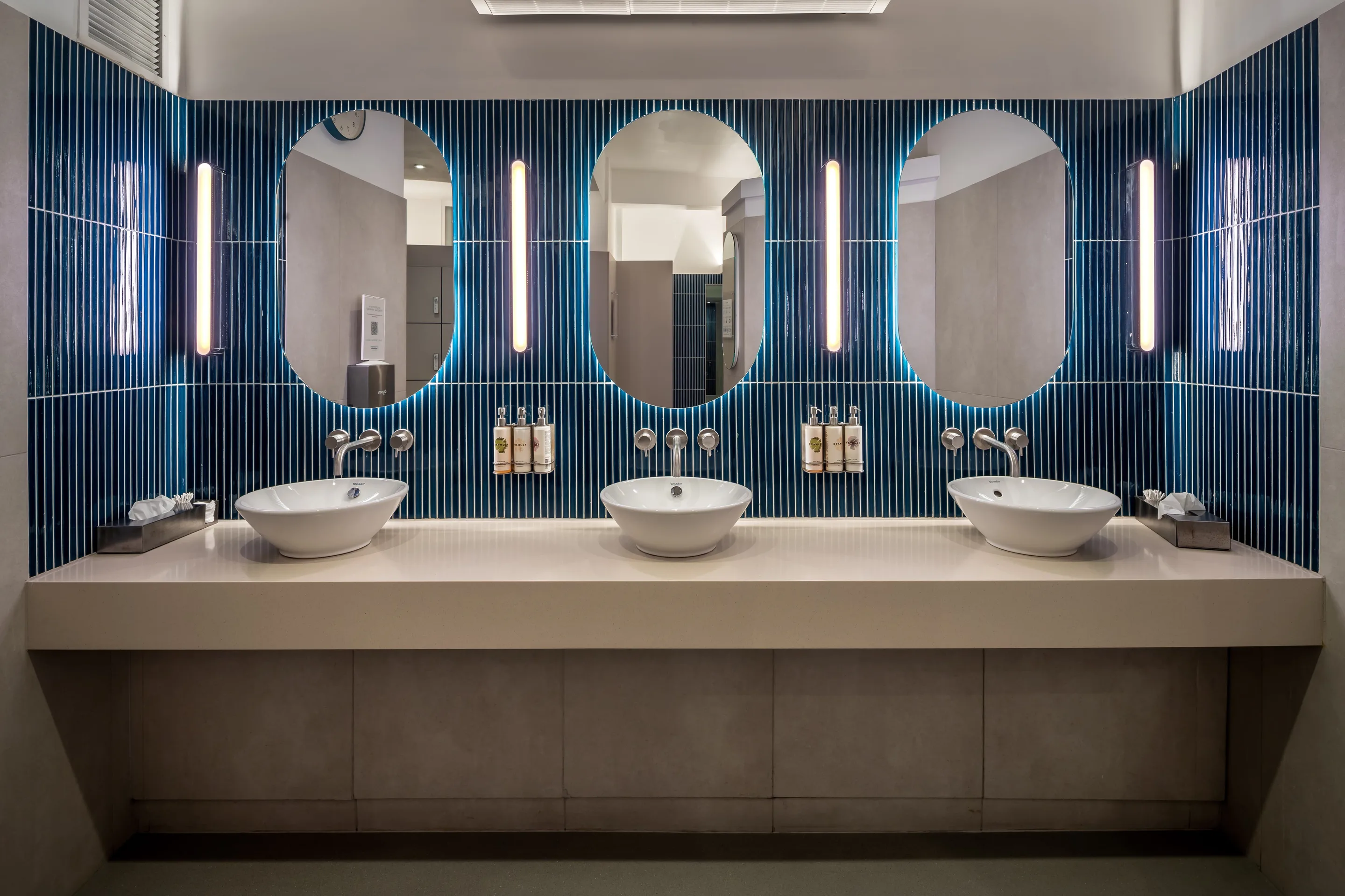Changing room sinks with blue tiling at Body Works West